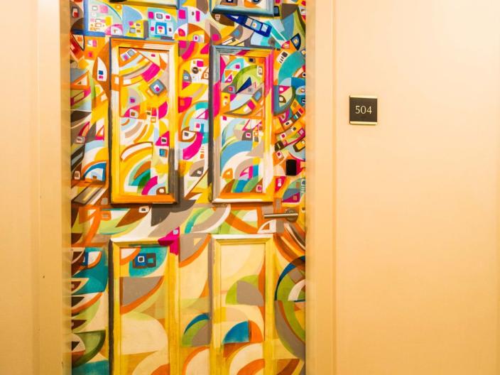A hotel door painted with a colorful pattern
