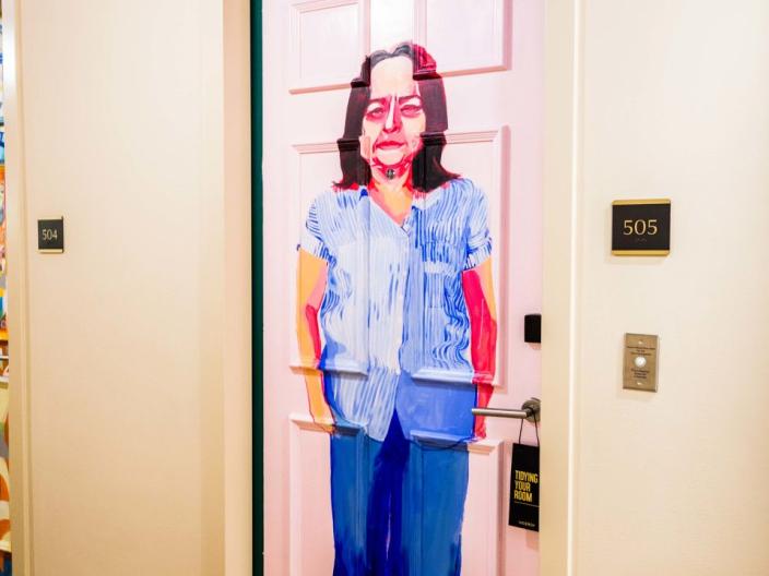 A hotel door painted with a standing woman