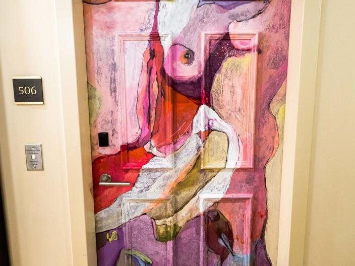 A hotel door painted with swirling colors
