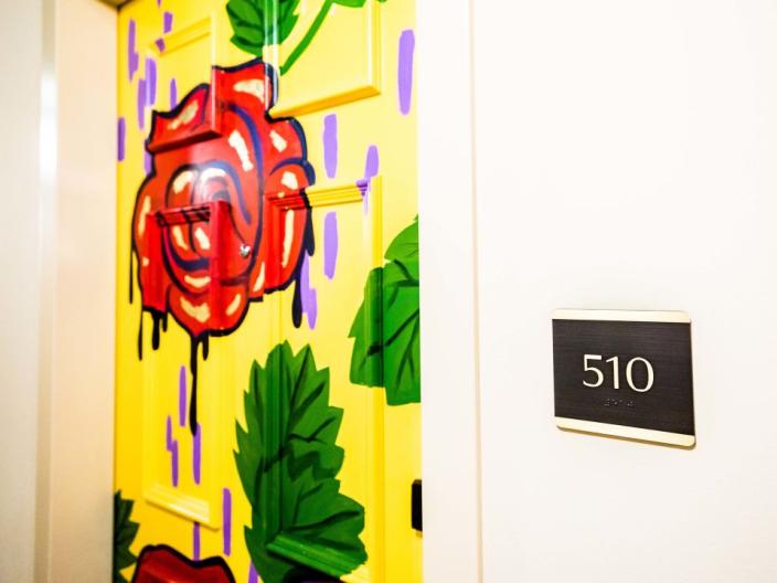 A hotel door painted with a red rose on a yellow background