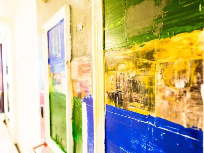 A hotel door painted with bands of textured color