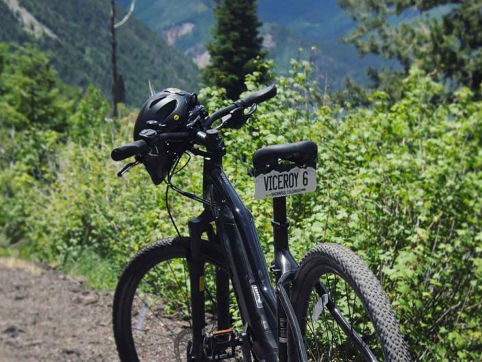 An E-Bike with a Viceroy licence plate parked on a mountainous Snowmass trail