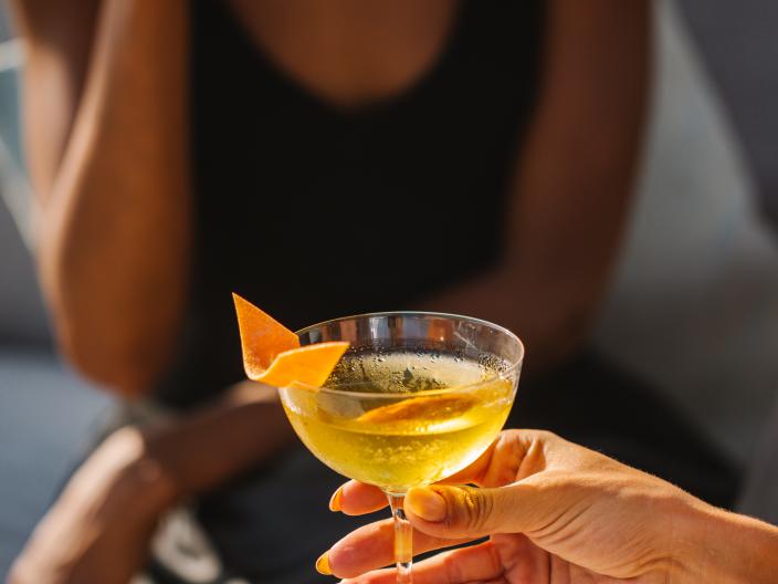 A woman enjoying a Chrysanthemum cocktail from Viceroy Los Cabos