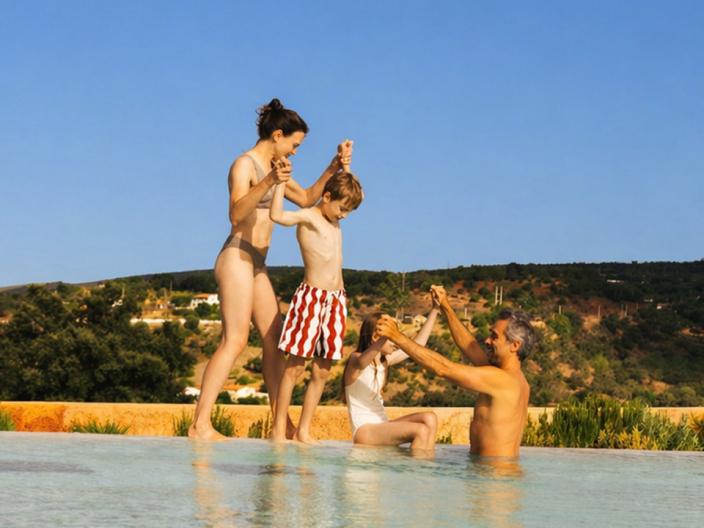 family playing at the pool