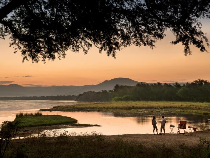 A couple camping at sunset