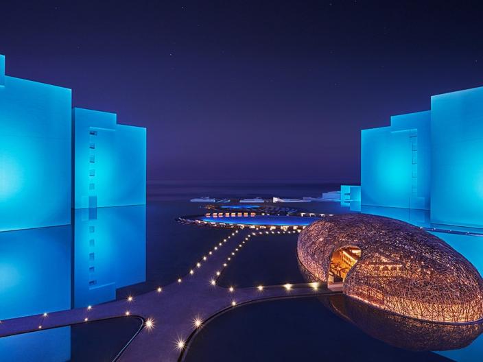night view of a hotel surrounded by water