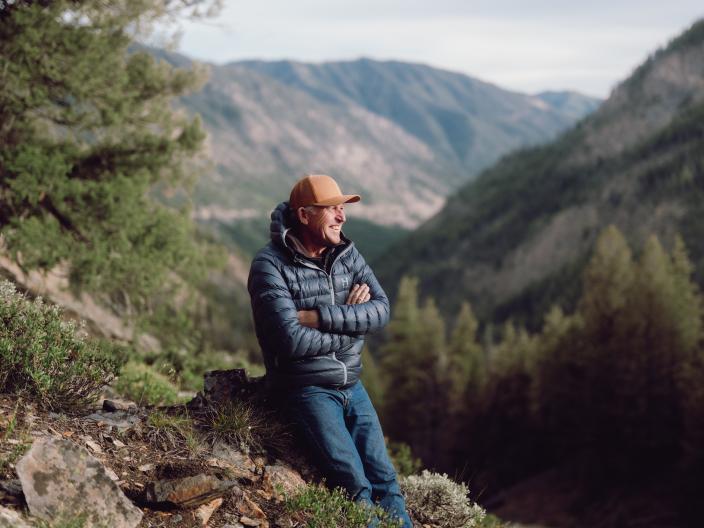 Mountaineer Ed Viesturs resting against a stump in a Sun Valley mountain range