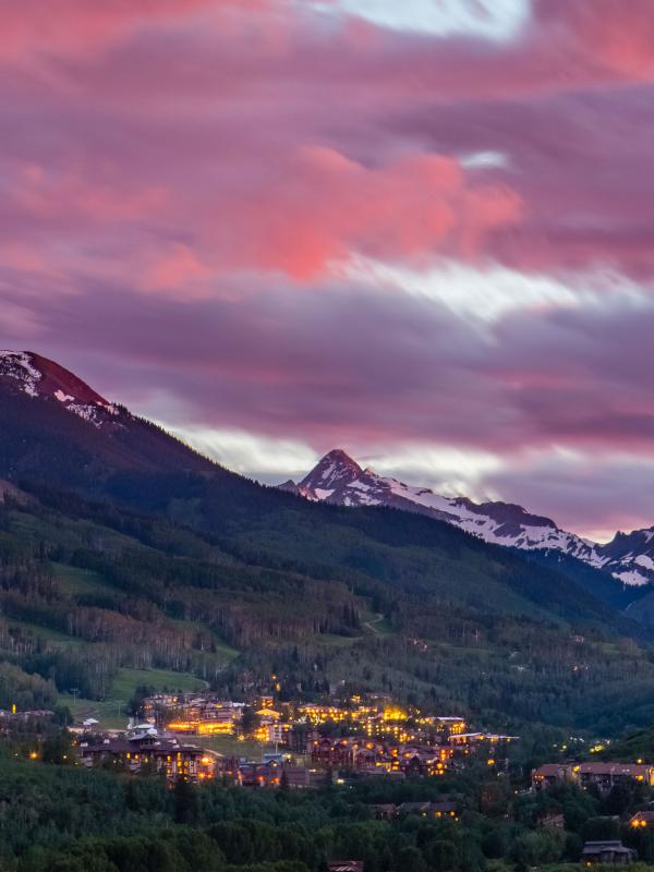 mountains in background with pink sky above the city below