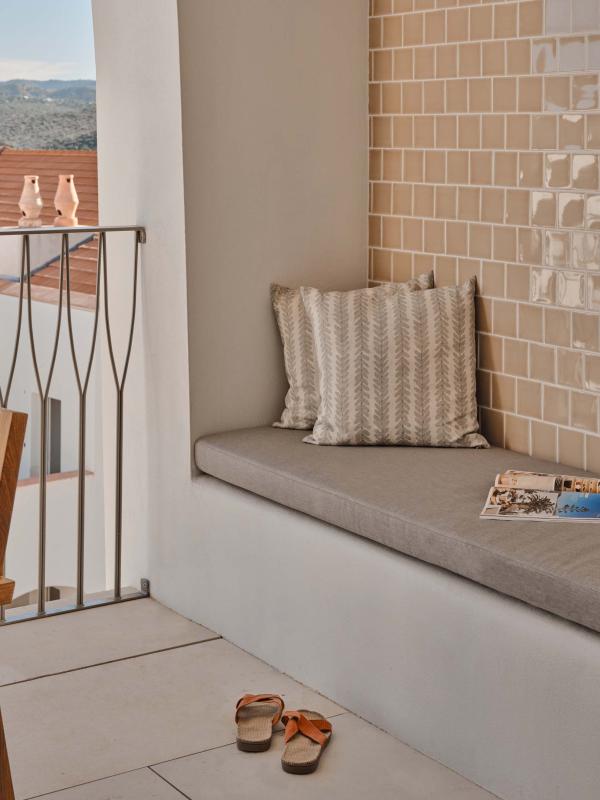Balcony with long bench and dining area
