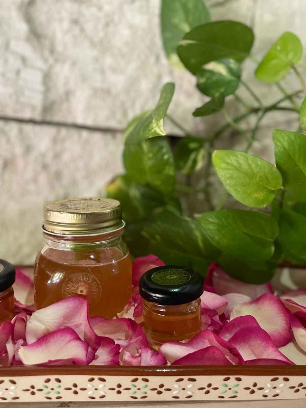 Jars of honey on a tray of flower petals