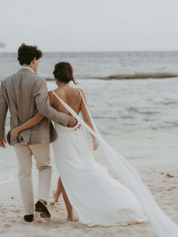 Bride and groom walking on the beach