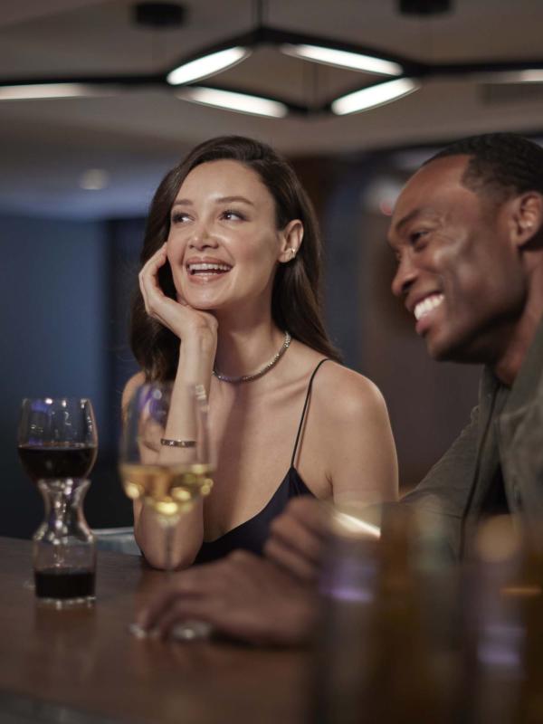 A man and a woman sitting at the bar