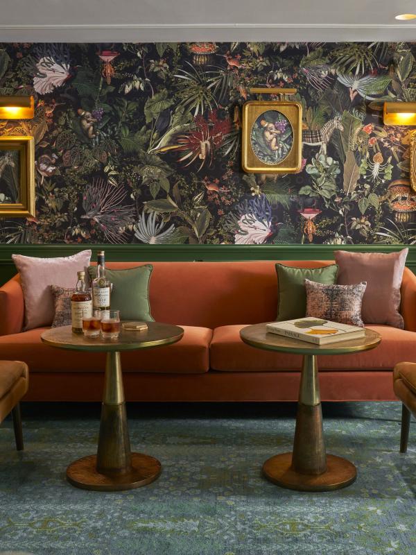 Green room with gold and orange accents including two chairs and a couch