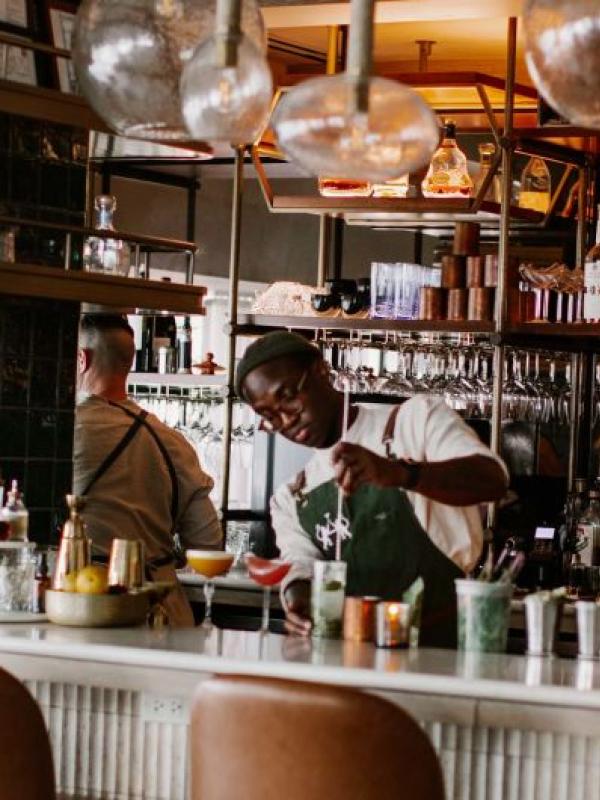 A bartender stirs a drink at the bar of Pandan restaurant