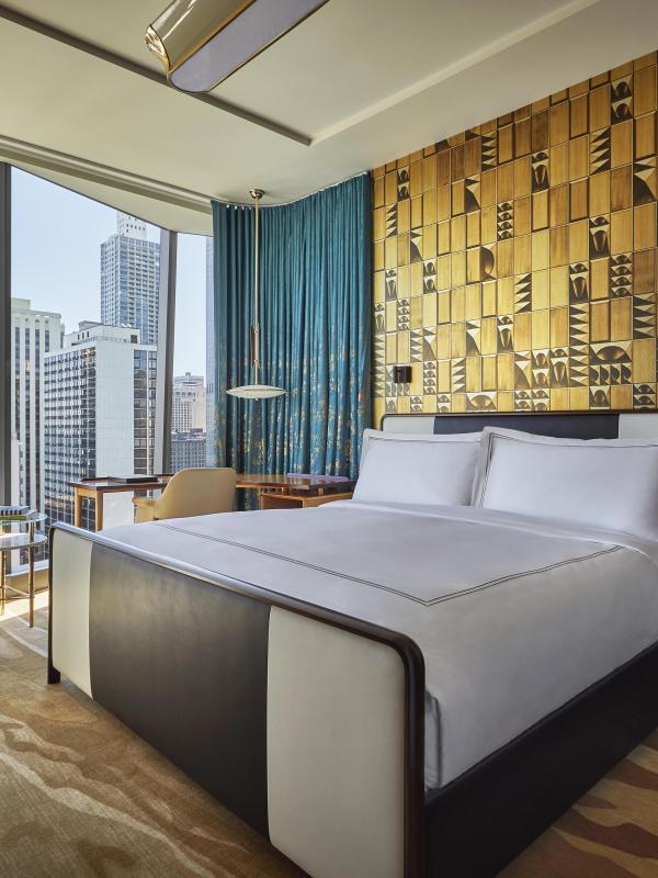 A room with floor to ceiling windows, a queen bed, and desk at Viceroy Chicago