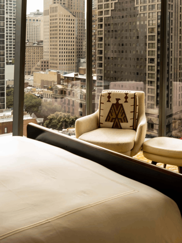 A chair against the floor to ceiling windows in a room at Viceroy Chicago