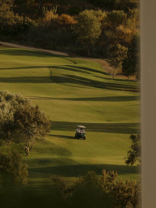 People riding a golf buggy on a green at Viceroy Ombria Algarve