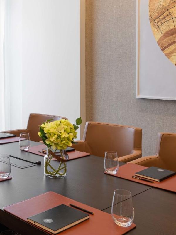 The Sky Boardroom at Viceroy Kopaonik Serbia, with office chairs surrounding a long meeting table and a large art piece on the wall