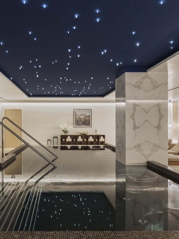 The spa at Viceroy Kopaonik Serbia, with a wading pool and recliners under a ceiling painted like a starry sky