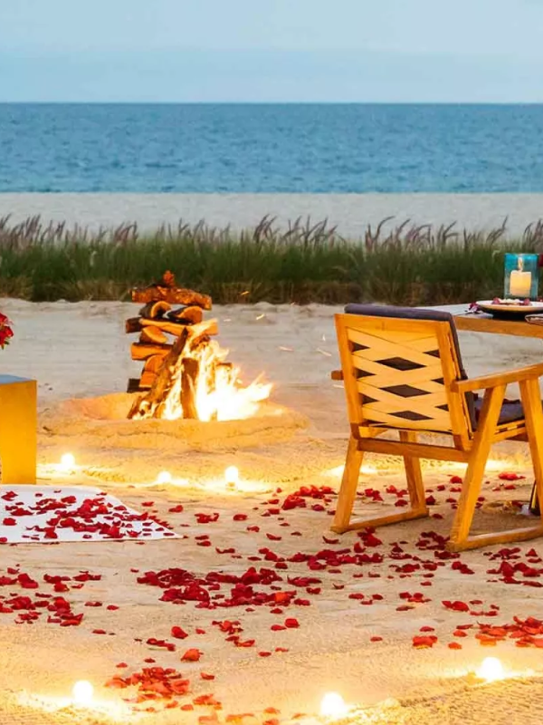 A table with wine and food setup on the beach at Viceroy Los Cabos