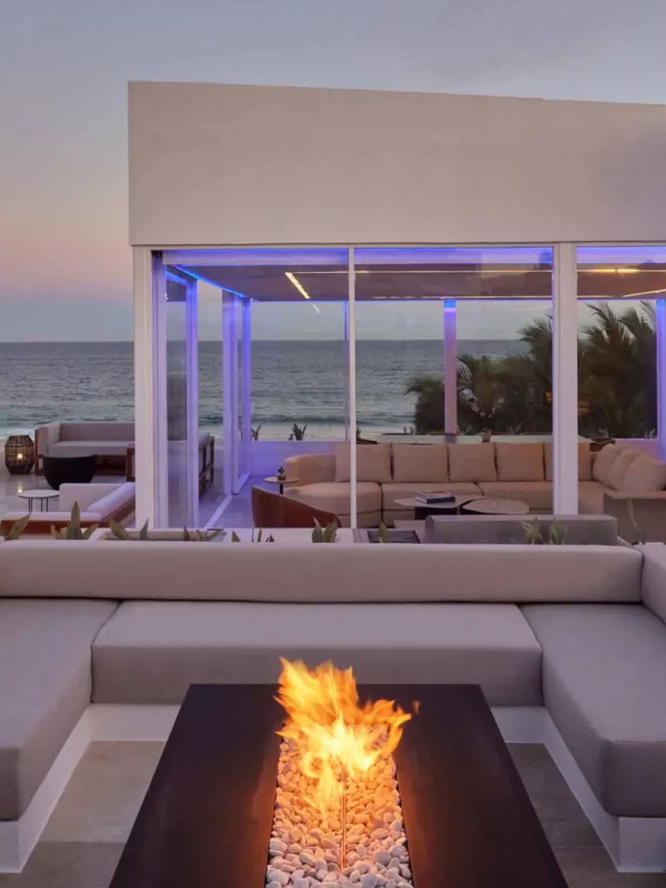 Exterior of a villas with a view of the ocean and a patio fireplace