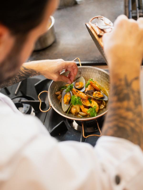 A chef at Umbria Kitchen at Viceroy Ombria Algarve cooks a seafood dish