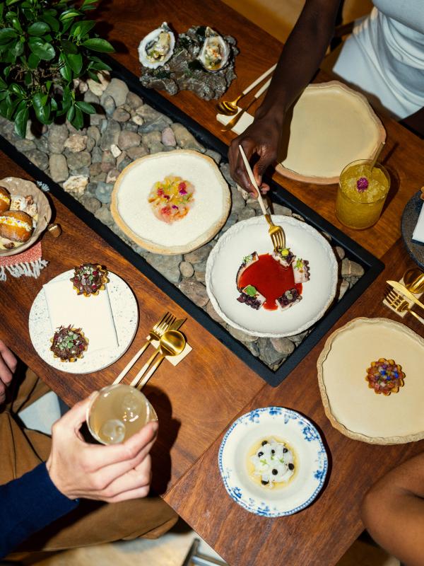 A spread of dishes to a customer at a restaurant at Ombria Algarve