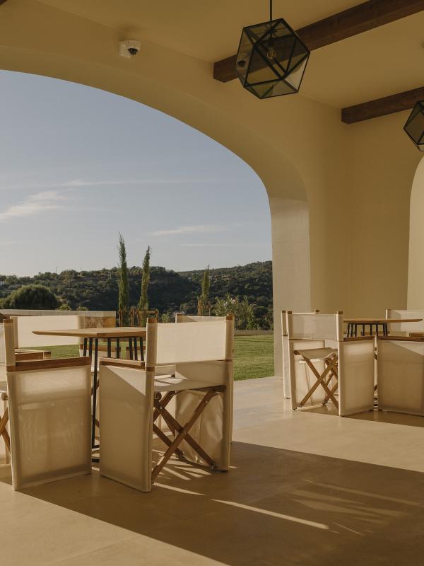 An outdoor space with 2 table and four chairs for each table looking out to the hills at Ombria Algarve