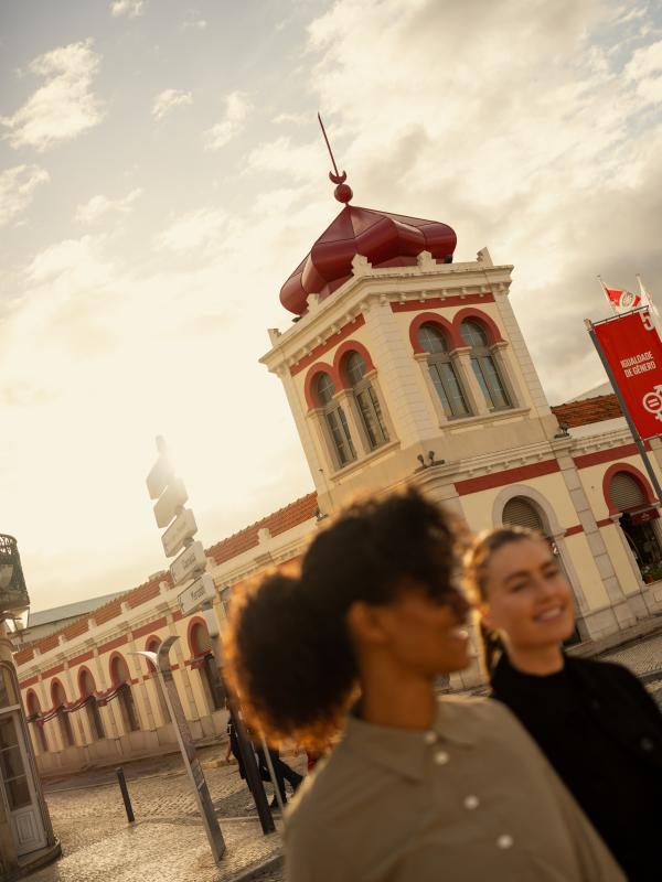 Two travelers walk past a historic building in the town of Loulé