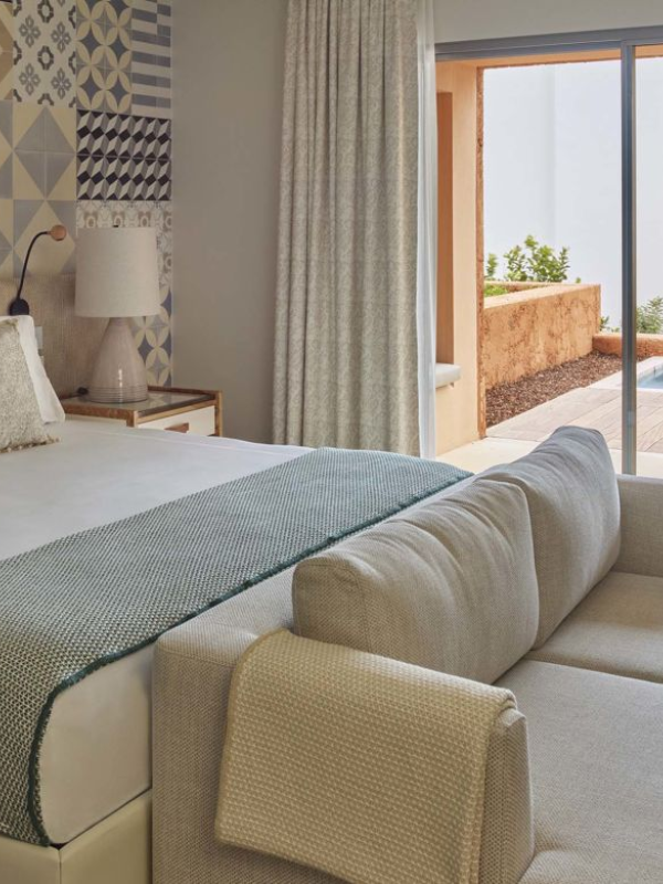 A king bed ina room with a couch, dresser, and a patio at Ombria Algarve