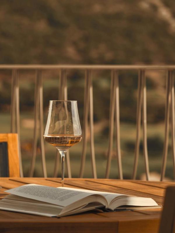 A patio table with a glass of white wine on top at Viceroy Ombria Algarve