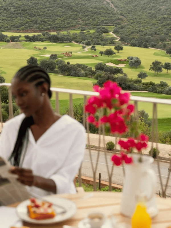 A woman reading the paper of a balcony at Ombria Algarve