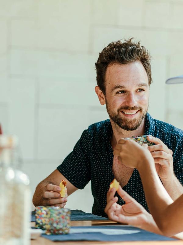A man clinking shot glasses with a woman at a bar 