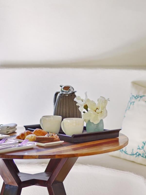 A small round table with coffee and breakfast food items at Viceroy Riviera Maya