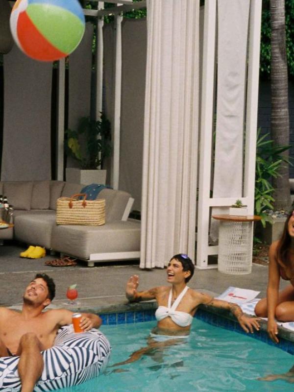 Guests at the Viceroy Santa Monica pool, dipping their toes in the water and passing a beach ball