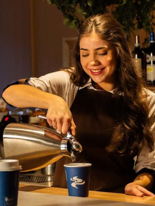 A server pours a cup of coffee at Café V
