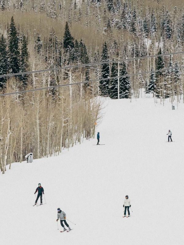Skiers descend Snowmass mountain