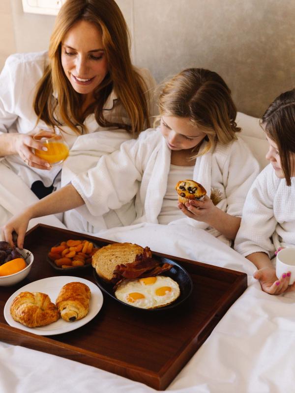 A mother and her two kids having breakfast in bed at Viceroy Snowmass
