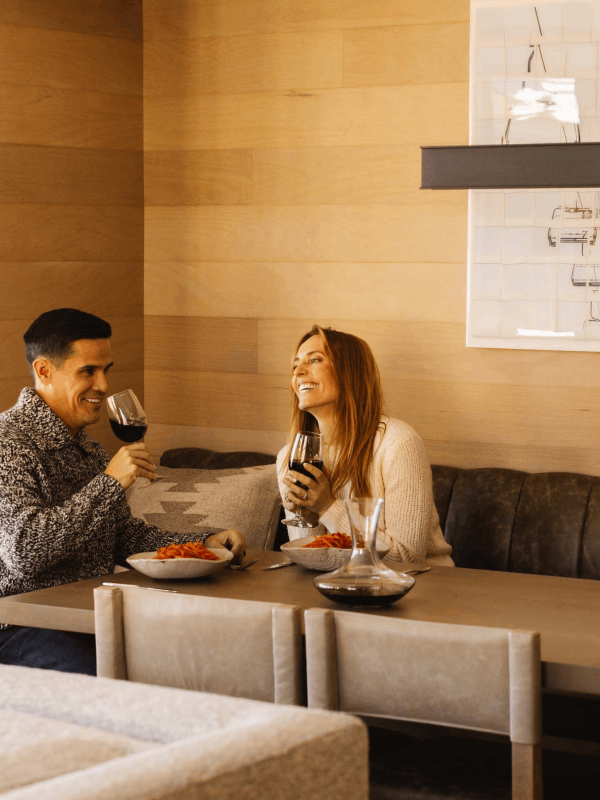A couple laughing, eating and drinking wine at Viceroy Snowmass