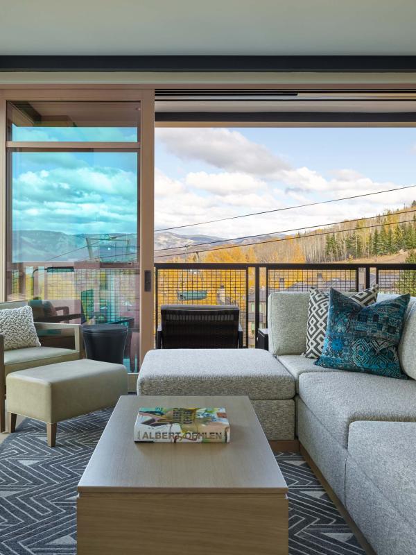 A room with an L-shaped couch and a fireplace at Viceroy Snowmass