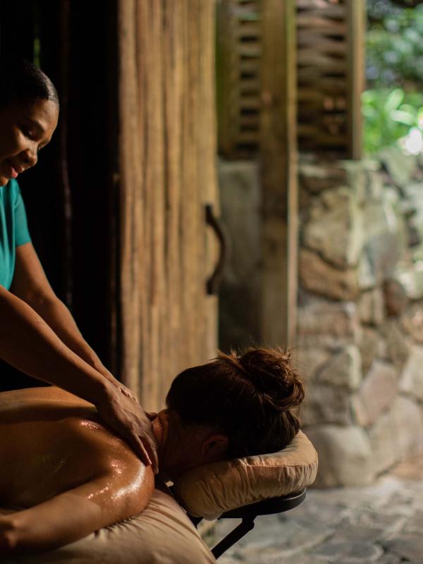 a woman receives a massage in a cabana next to a tranquility pool