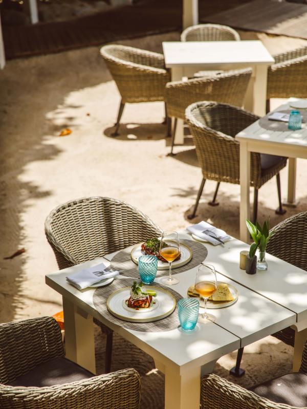 Glasses of wine and a shareable dish on a patio table at Bonté