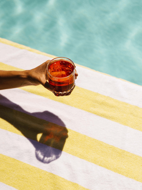 An arm holding a cocktail poolside at Viceroy Washington