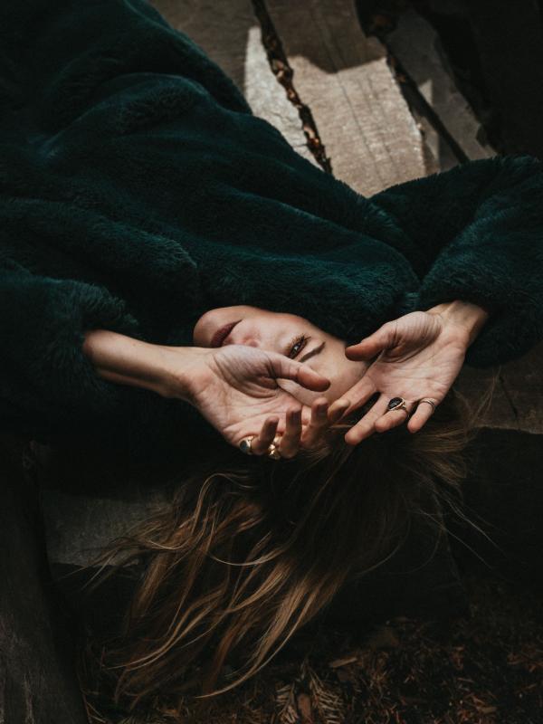 A woman laying on the floor with her hands over her face