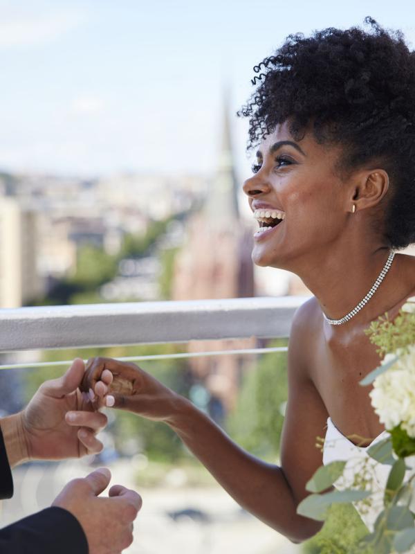 A bride and groom holding hands and laughing on the rooftop patio at Hotel Zena, Washington DC