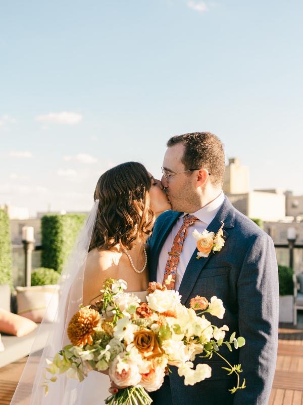 A bride and groom kissing at a Viceroy Washington DC rooftop wedding