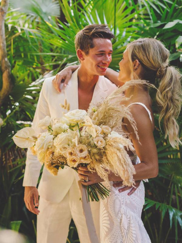 A couple happily smiling at each other in a beautiful tropical resort