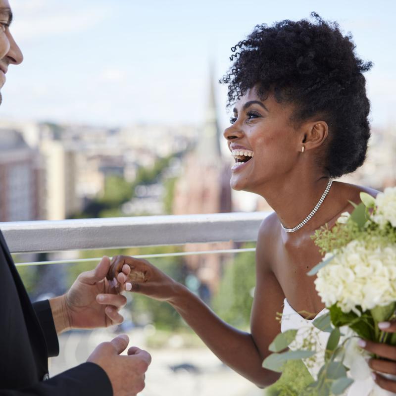 A bride and groom holding hands and laughing on the rooftop patio at Hotel Zena, Washington DC