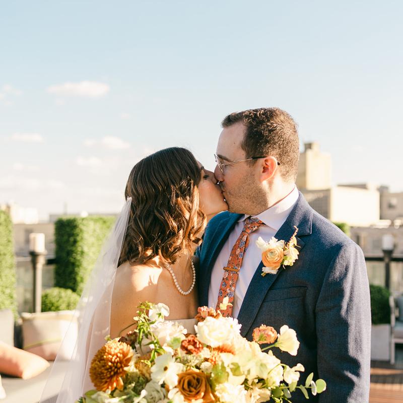 A bride and groom kissing at a Viceroy Washington DC rooftop wedding