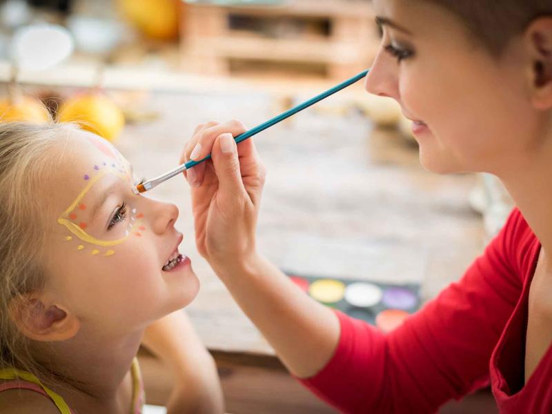 woman paints a child's face